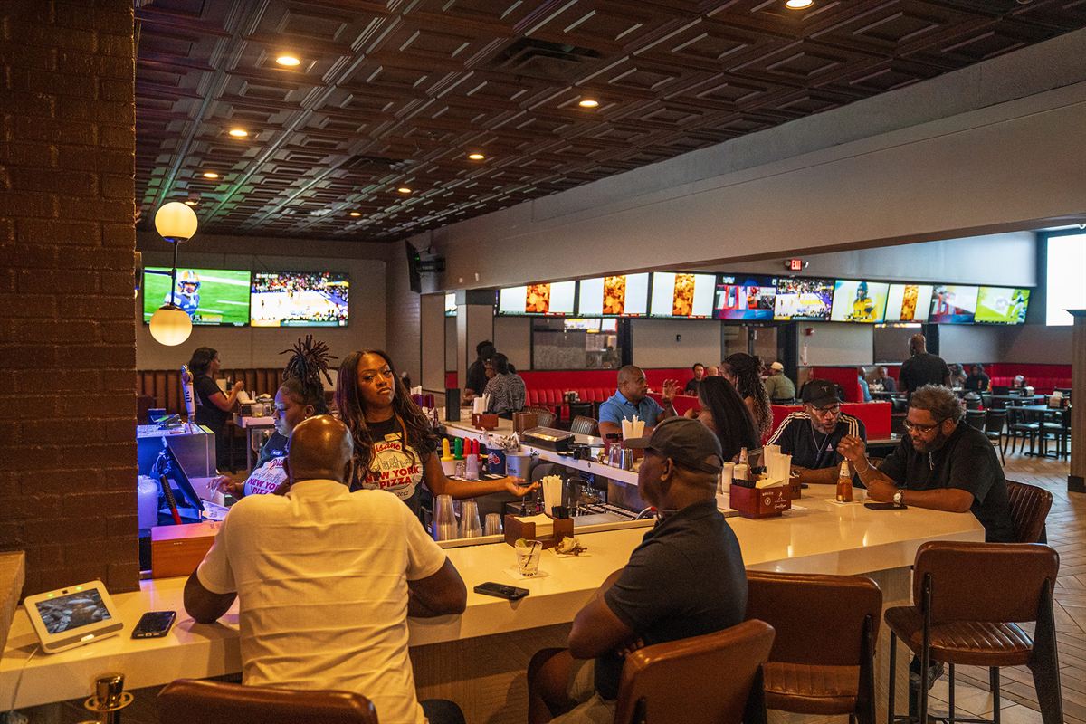Guests at the bar with the game on the TVs