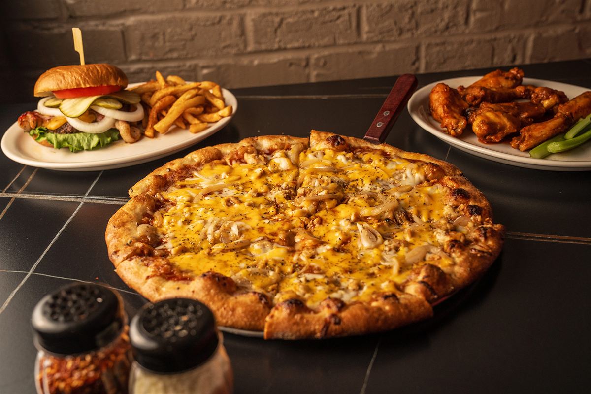 A pizza, a burger and wings on the table